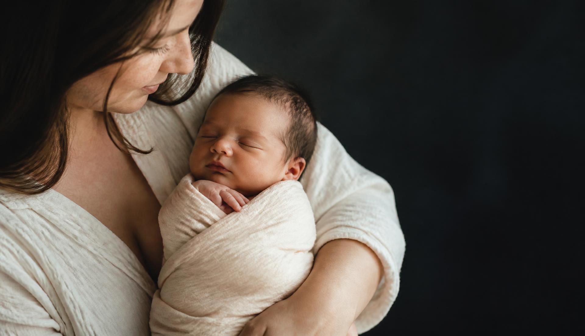 Mother holding a sleeping newborn